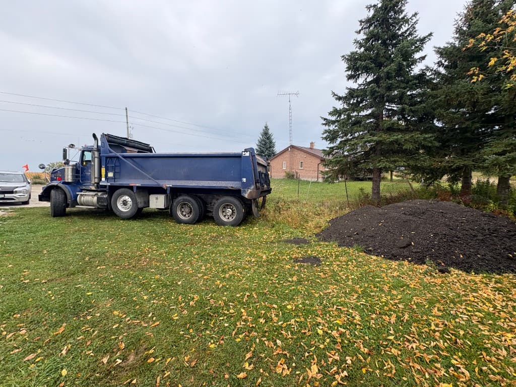 Dump truck beside a pile of asphalt millings for the new parking area