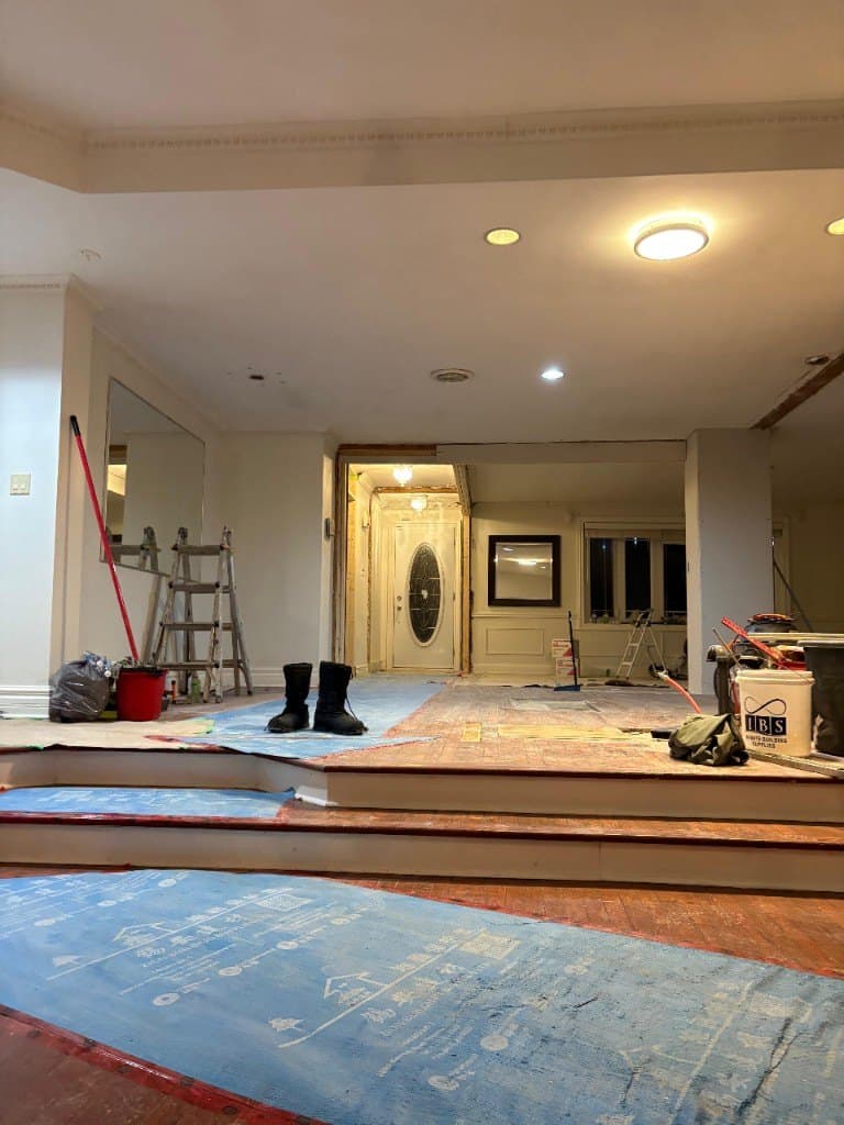 Inside the house during renovation, with the expanded hall and floors covered for the work